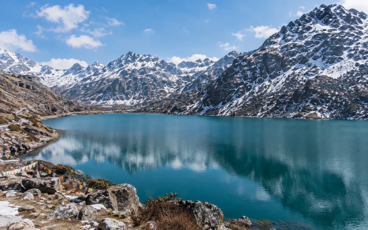 Tsomgo Lake surrounded by snowy mountain slopes